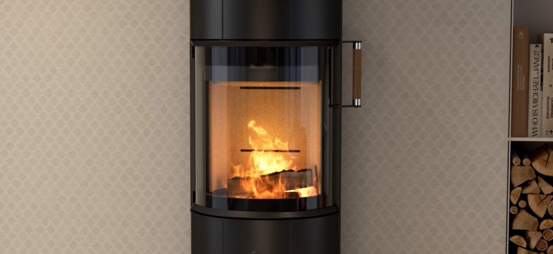Black wood-burning stove Scan 67 with oak handles in front of a beige checkered wallpaper with a fire in the fireplace