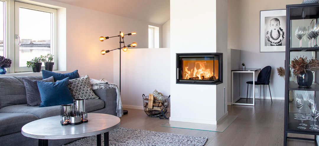 Fireplace insert with glass on two sides Scan 5003 in a white modern living room with gray sofa and black furniture