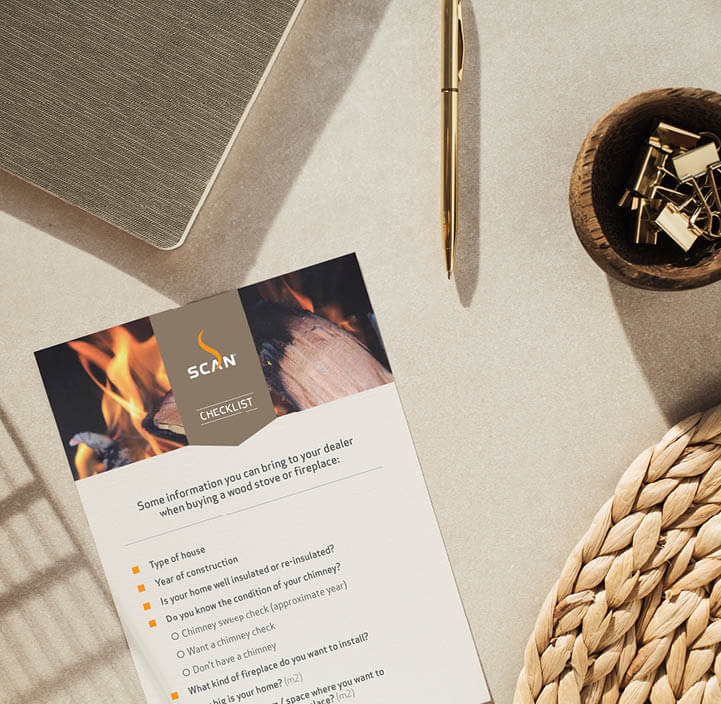 Image of checklist for buying a fireplace lying on a table next to computer pen and paper clips