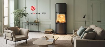 Black fireplace Scan 87 and log Red Dot Award Winner 2022 in light green interior with light brown sofa and recliner