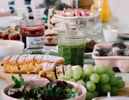 Danish easter buffet with pink bowls and lots of different dishes on a table with white table cloth