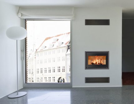 Black fireplace insert with flames Scan 1005 recessed into the wall in a white living room with large windows