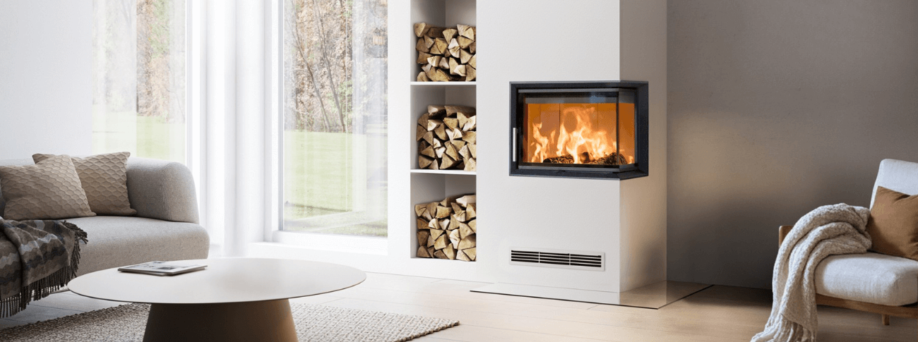 Modern built-in fireplace Scan 5103 FR with glass front and right side, integrated into a bright interior with wood niche and visible flames.