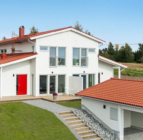 White house semi-detached house with orange roof and carport